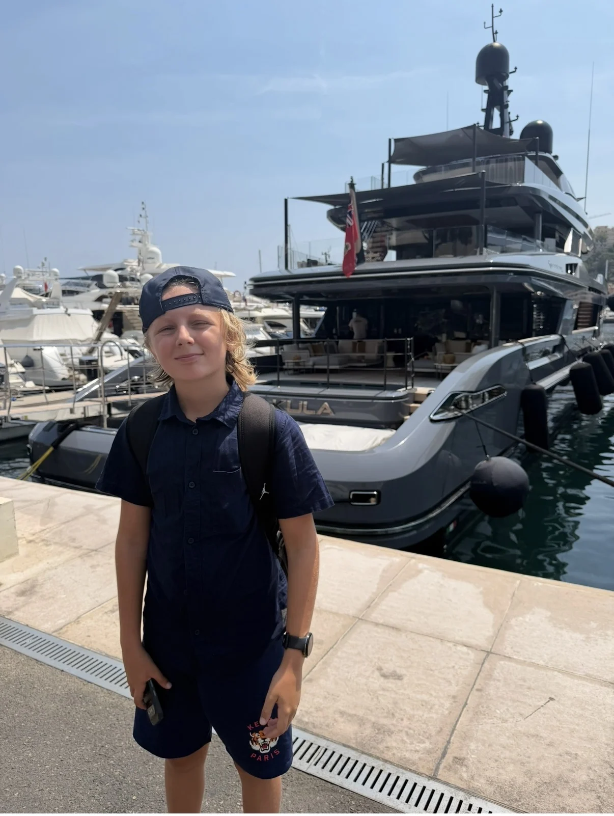Rocco by the harbour with yachts behind him
